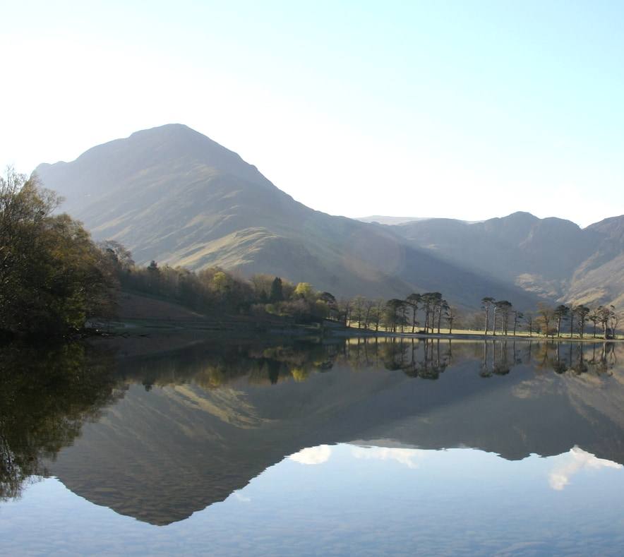 A range of mountains reflected whole in a lake lying completely still