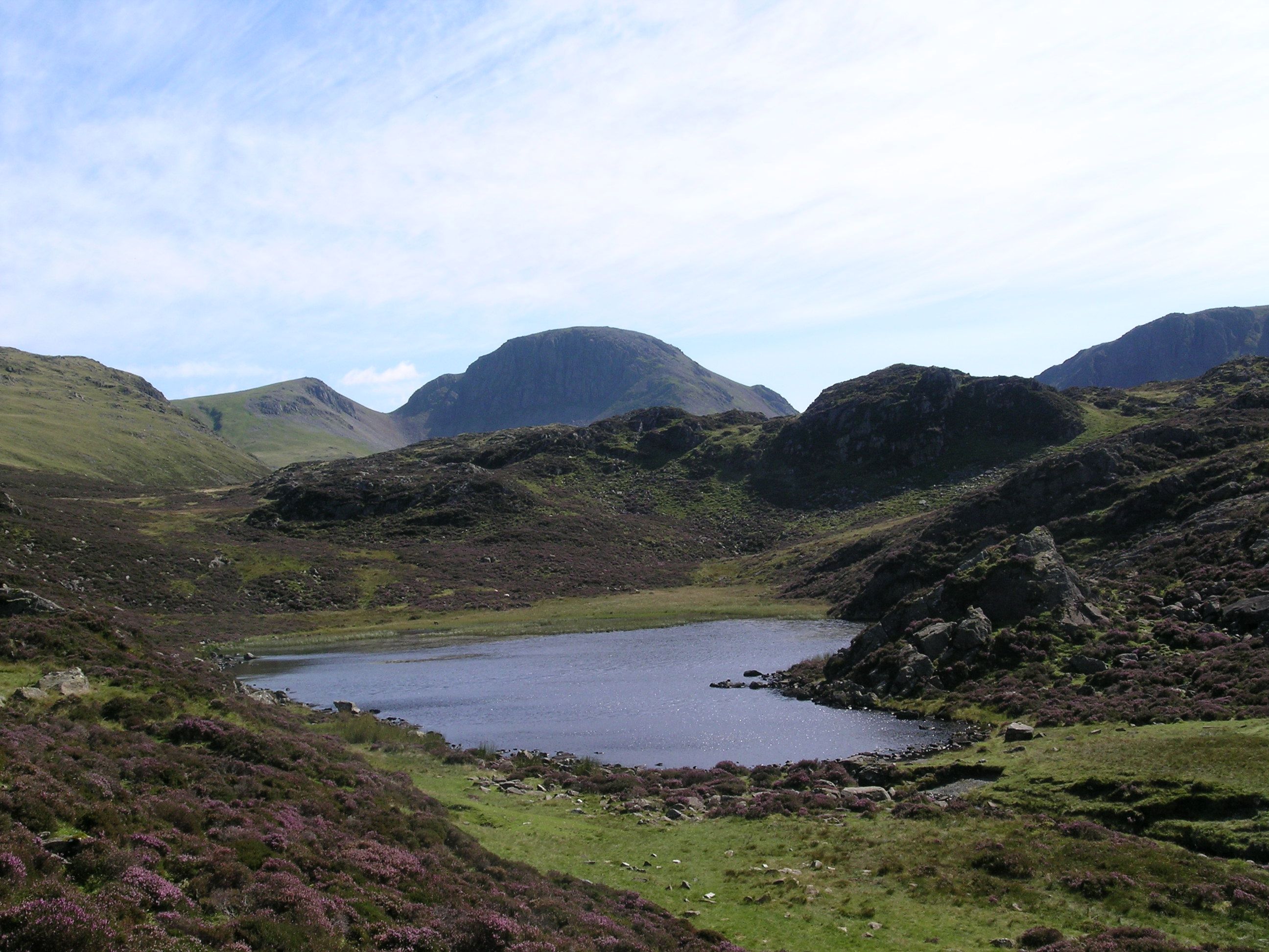 A rocky outcrop beside a mountain tarn on the open fell