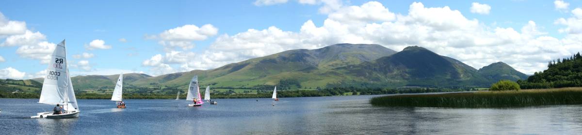 Sailing dinghies out on Bassenthwaite Lake with Skiddaw rising behind