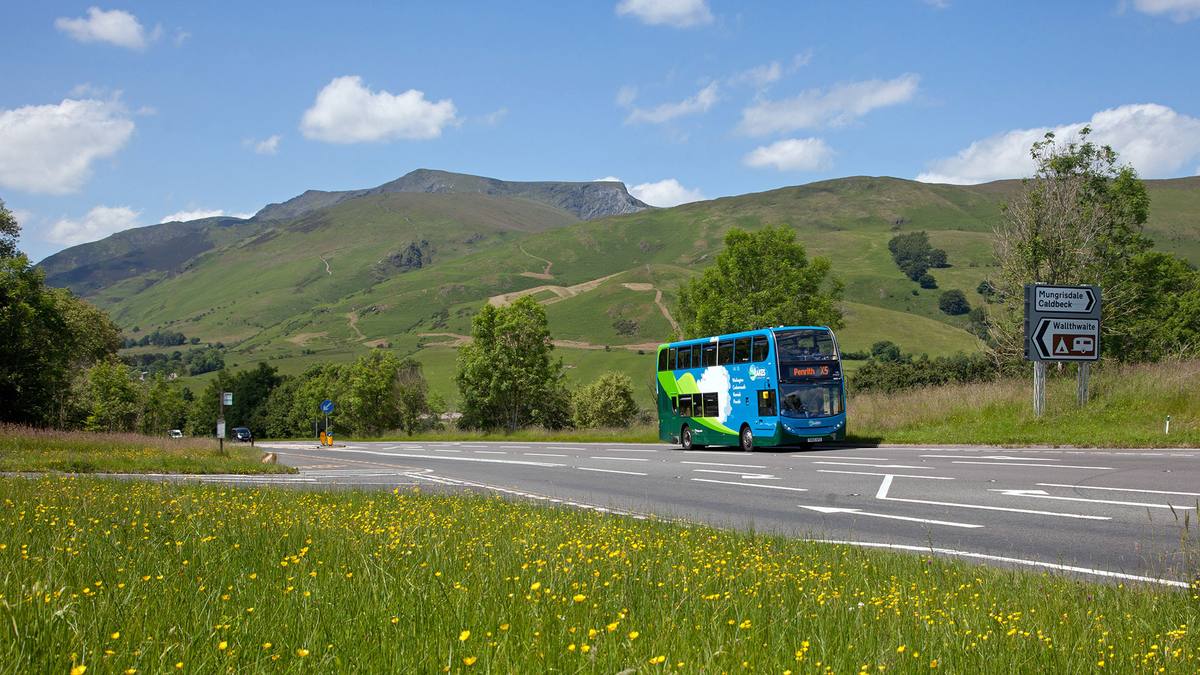 bus from penrith on the road with green grass and mountains