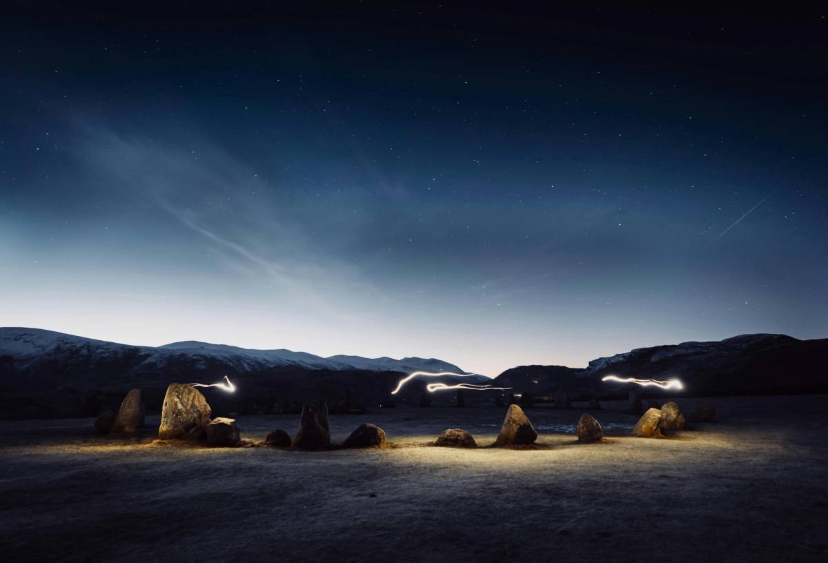 The standing stones of Castlerigg at dawn with mist lying across the fells behind
