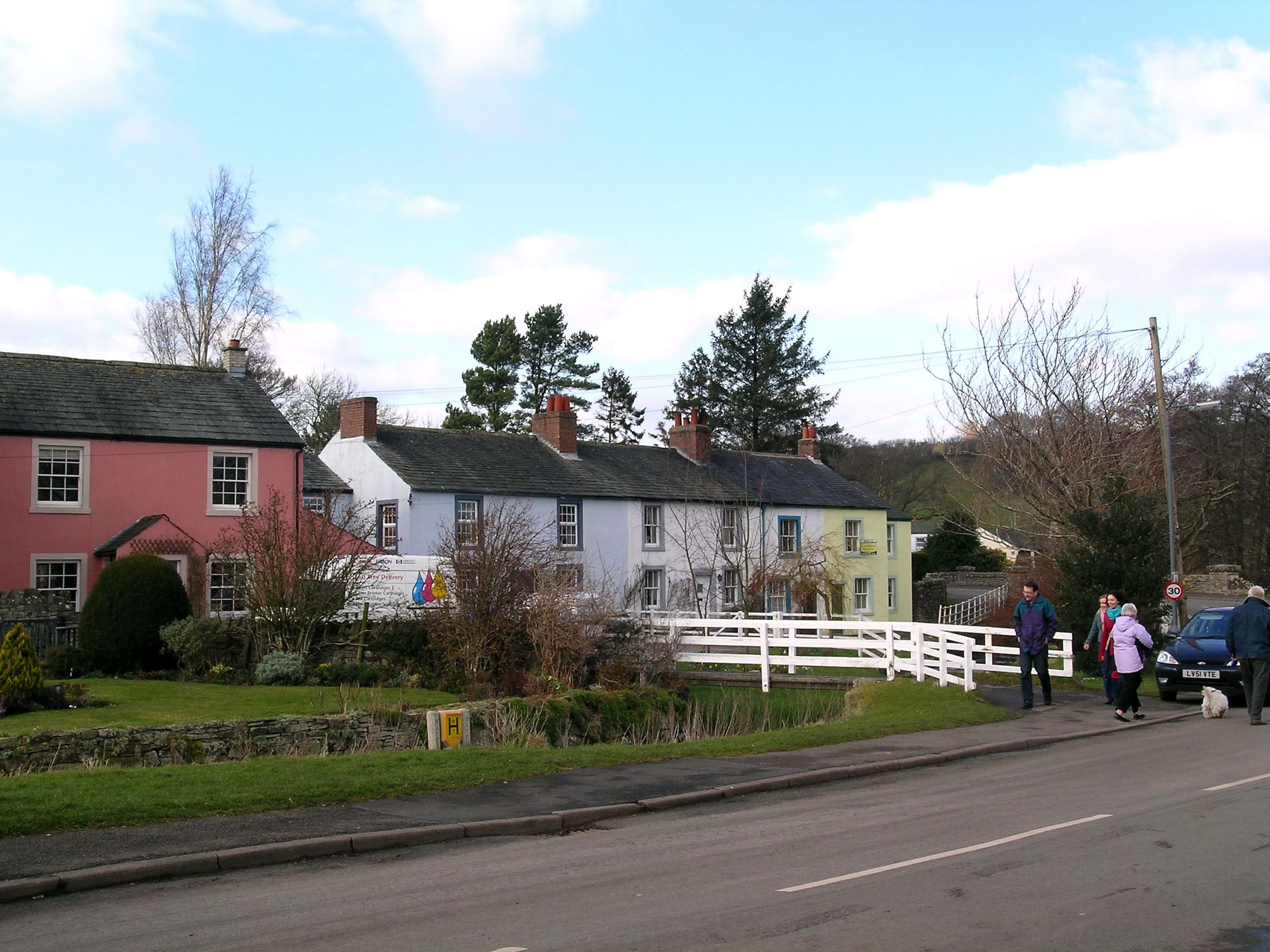 A row of village cottages with one washed pink beside the road at Ireby