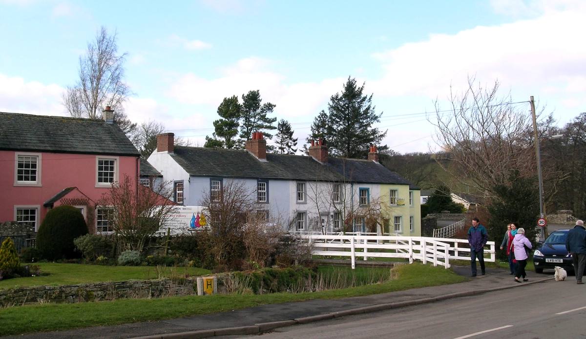 A row of village cottages with one washed pink beside the road at Ireby