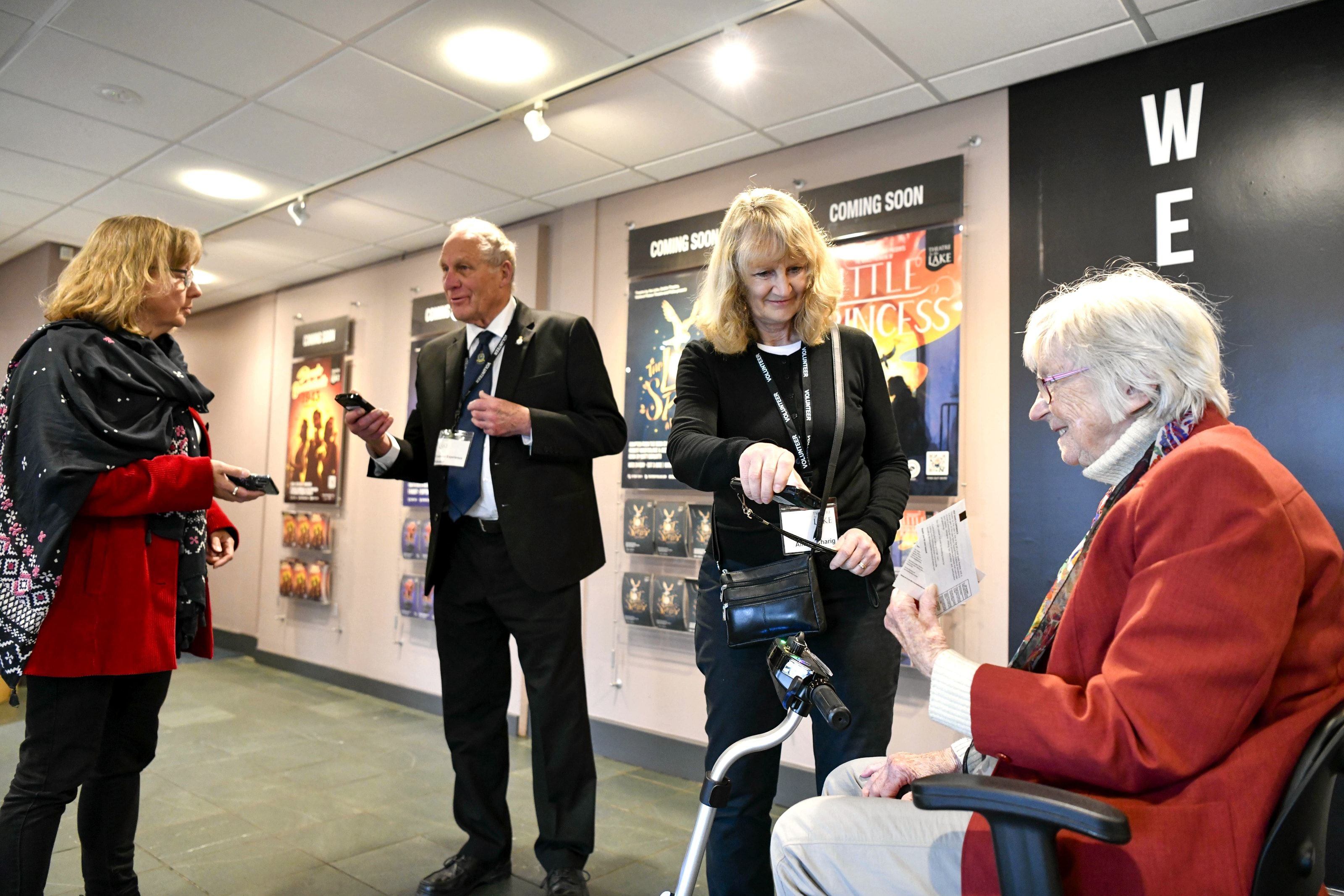 Theatre volunteers checking tickets as the audience arrives in the foyer