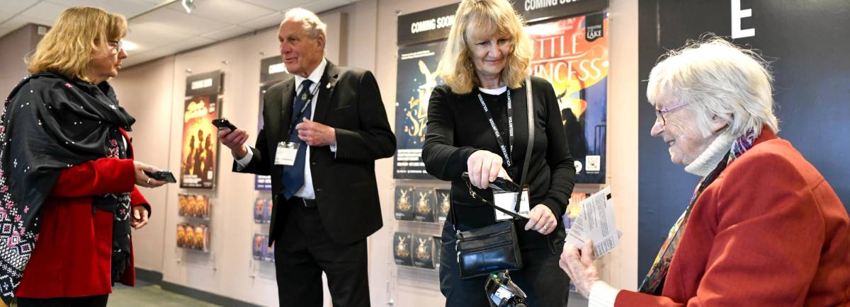 Theatre volunteers checking tickets as the audience arrives in the foyer