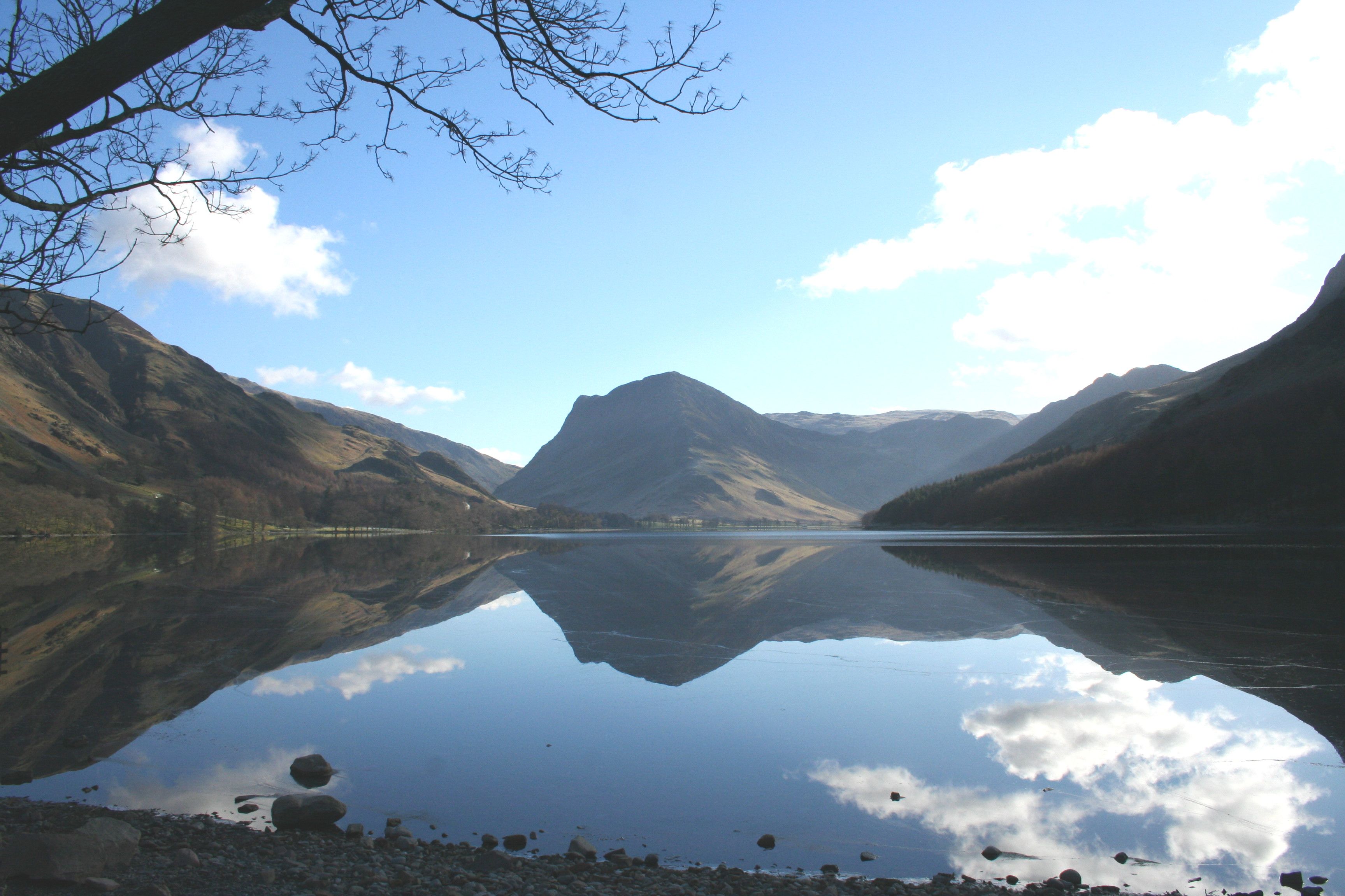 fleethwith pike at the foot of buttermere lake and mountain reflections on the water