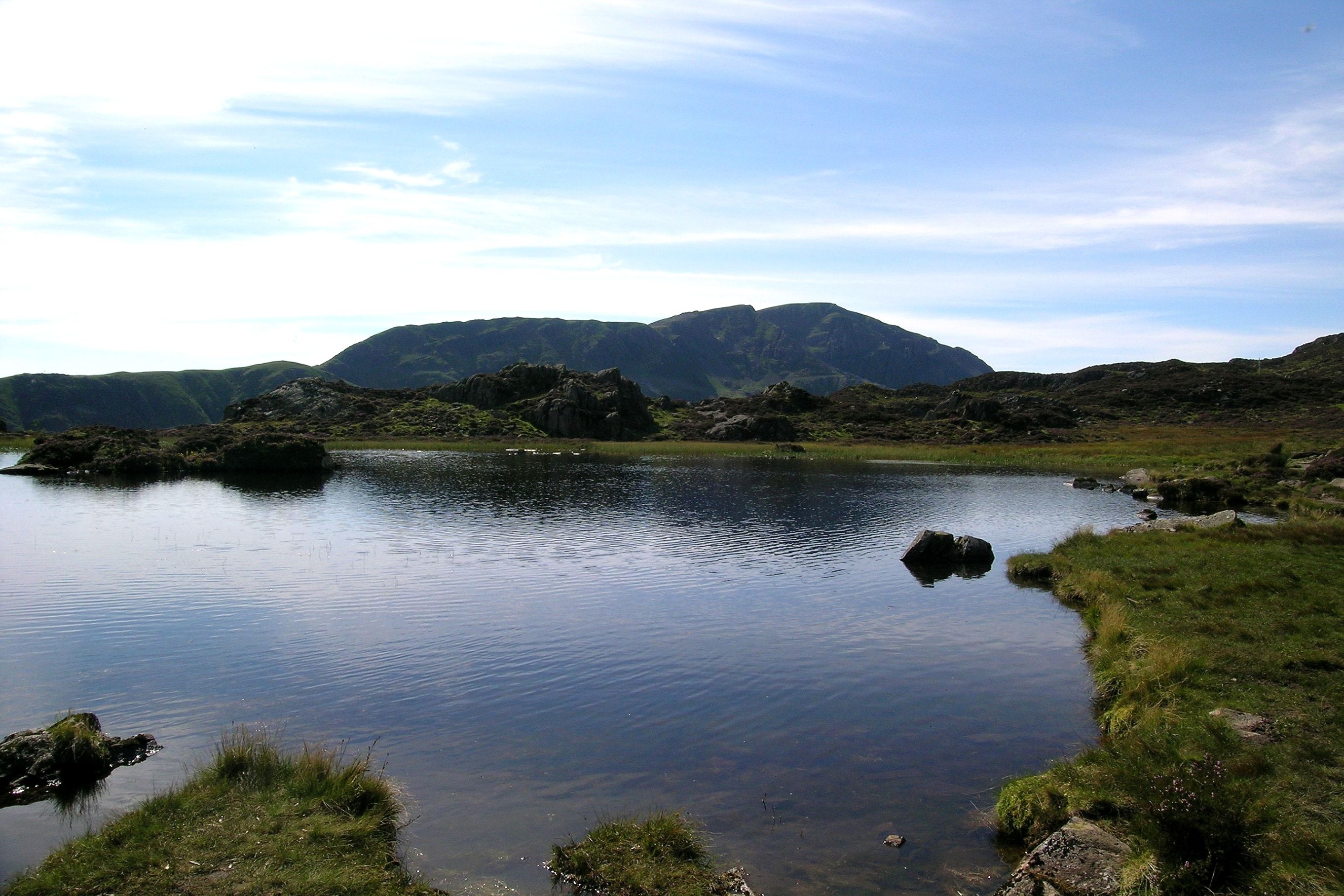 A rocky outcrop beside a mountain tarn on the open fell