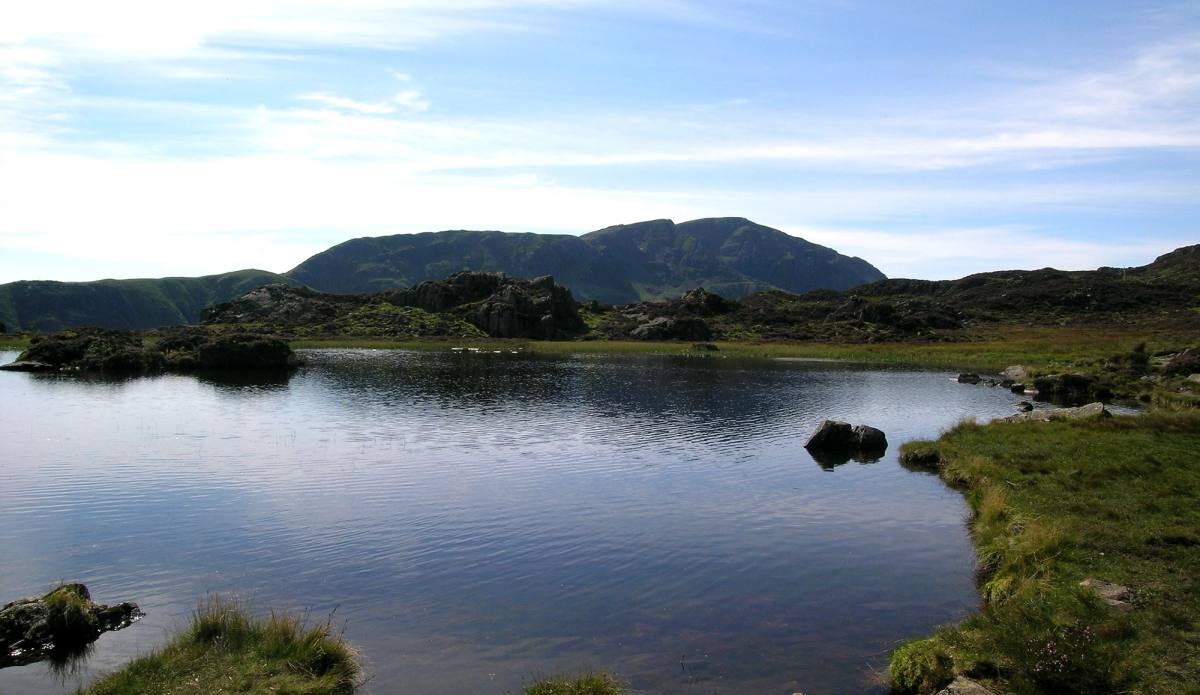 A rocky outcrop beside a mountain tarn on the open fell