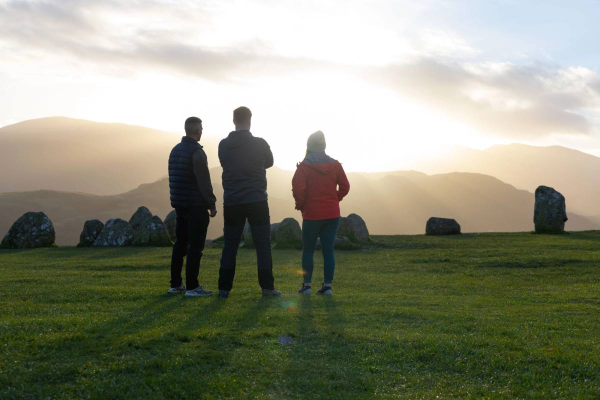 three people at  castlerigg stone circle