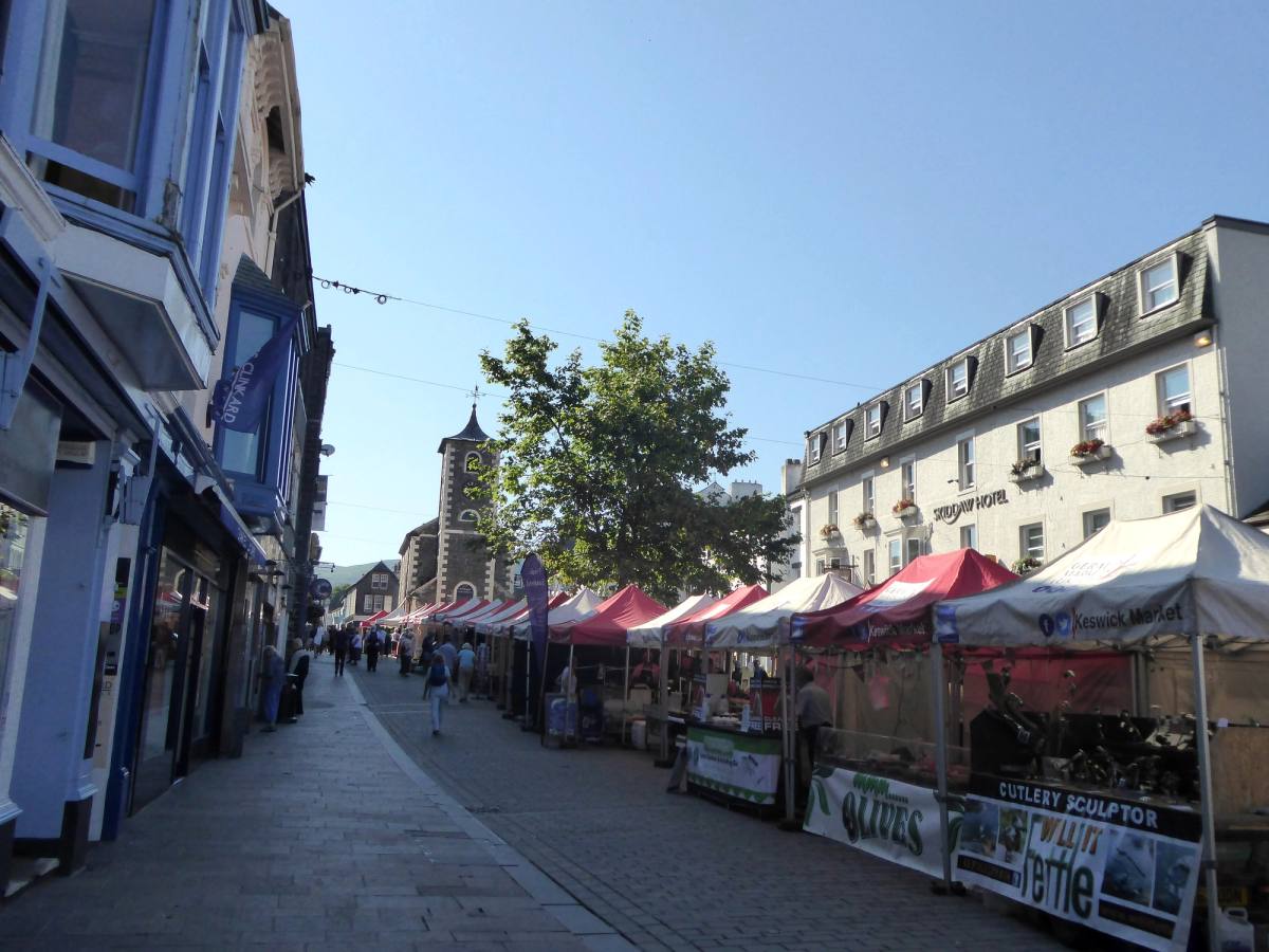 Covered market stalls set out down the middle of Keswick main street on market day