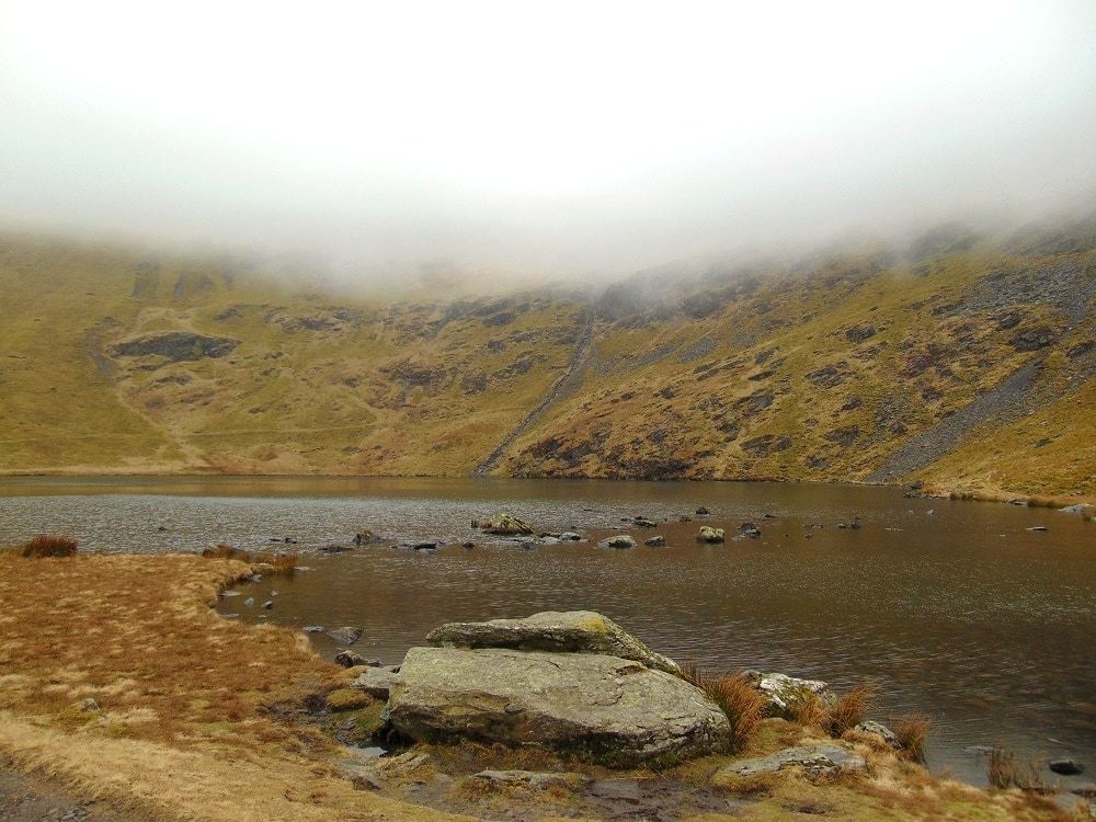 A boulder on the shore of a high mountain tarn