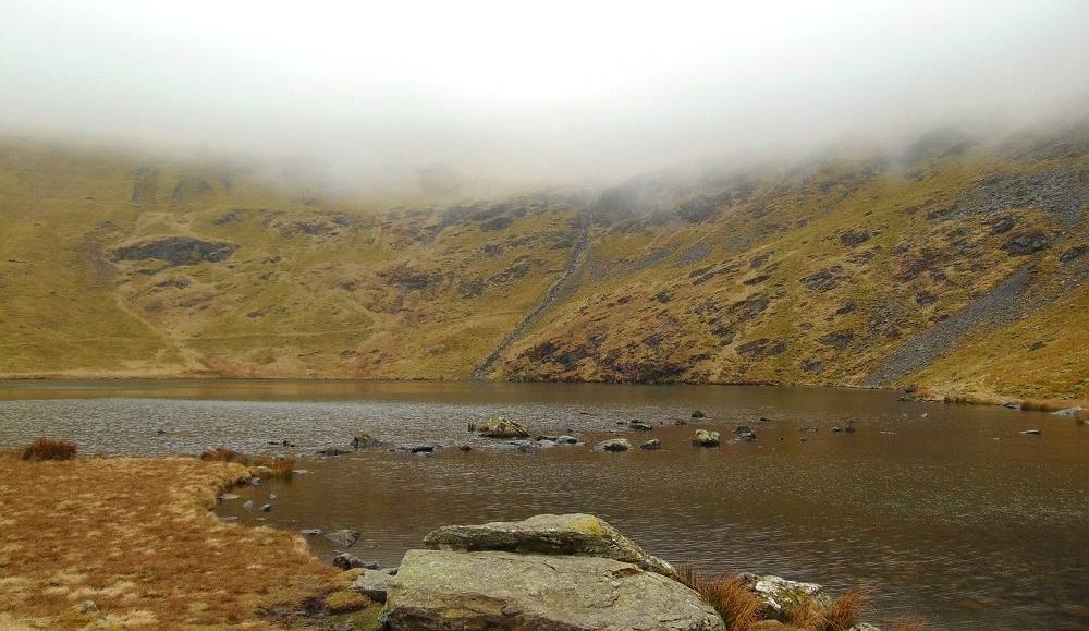 A boulder on the shore of a high mountain tarn