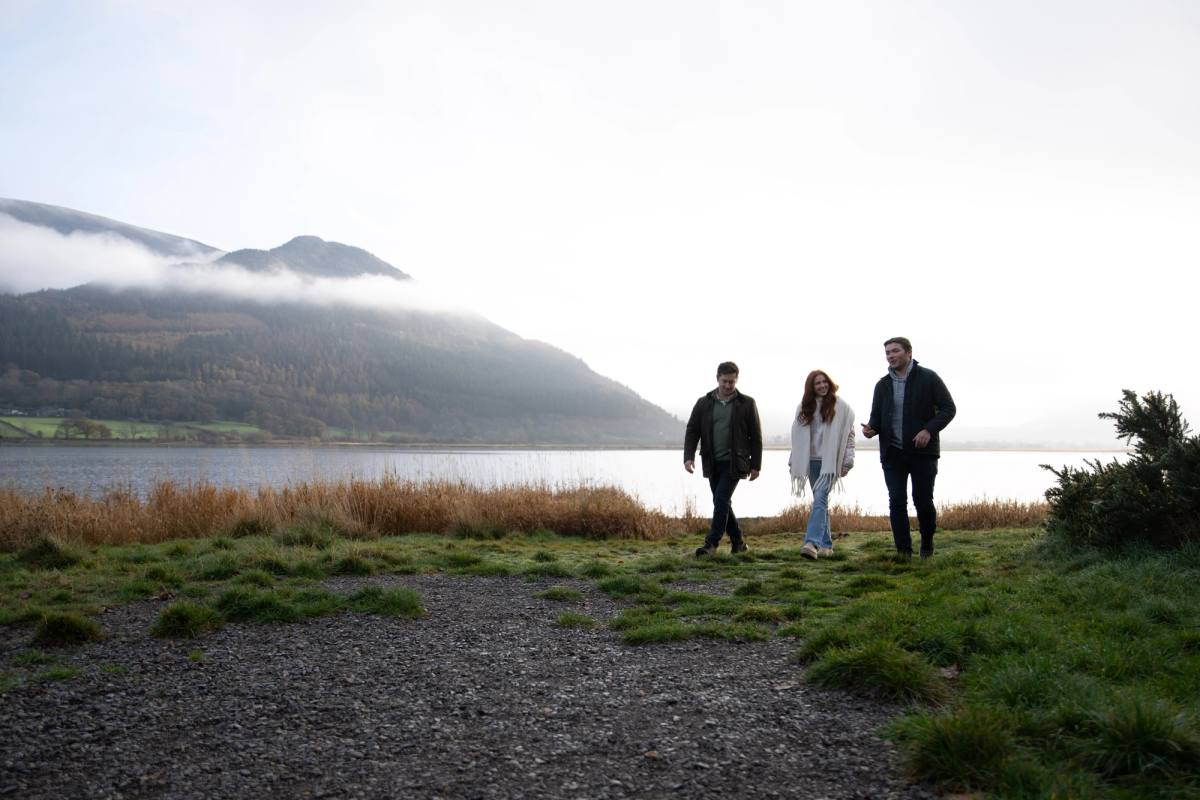 three people walking on the shores of bassenthwaite lake