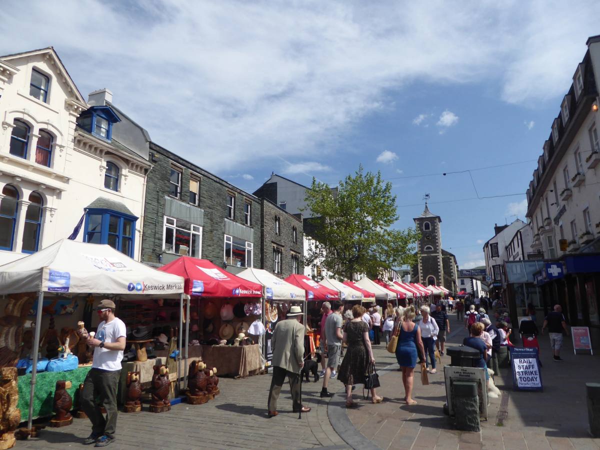 Covered market stalls set out down the middle of Keswick main street on market day