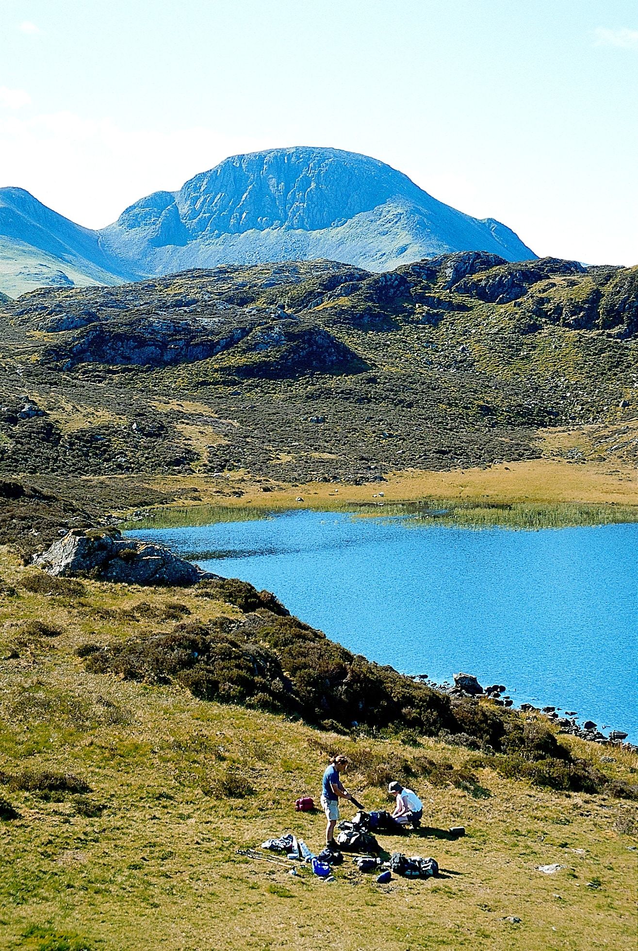 Walkers resting on the fell above a mountain tarn
