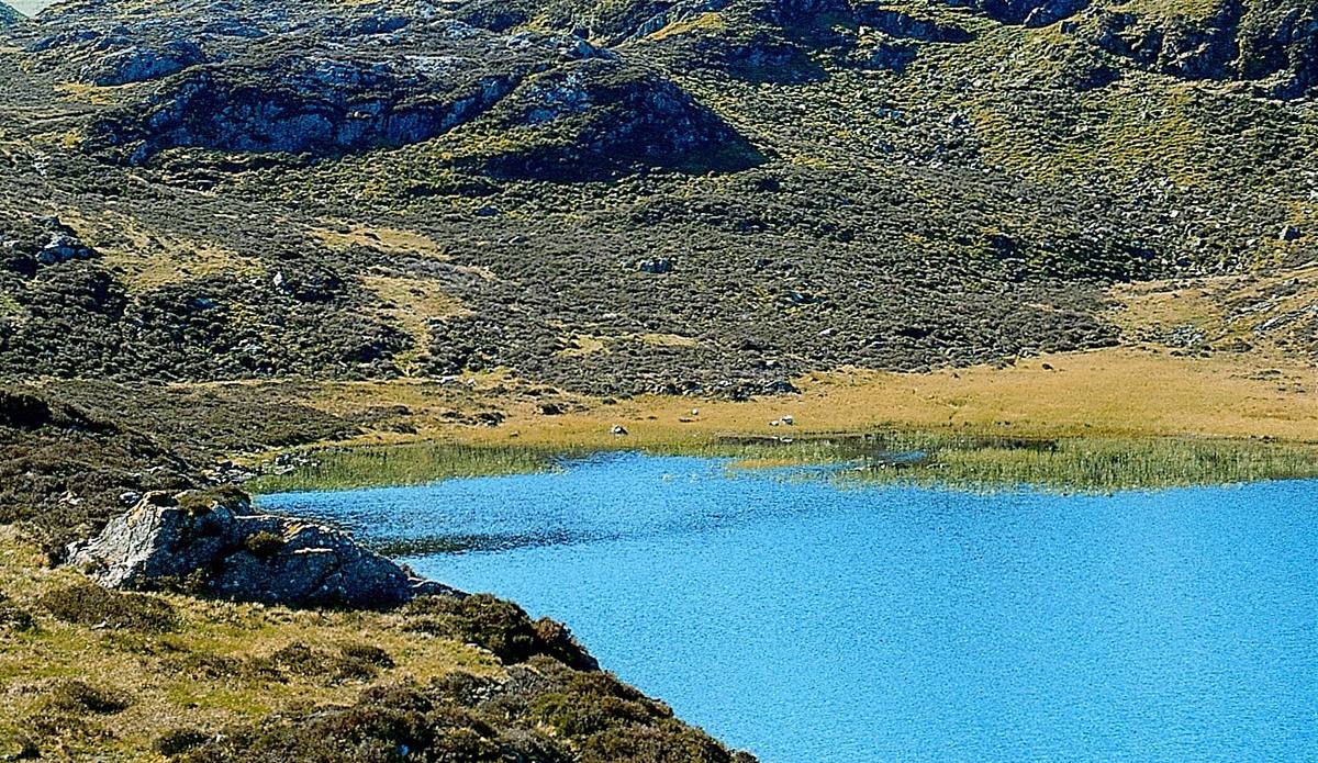 Walkers resting on the fell above a mountain tarn