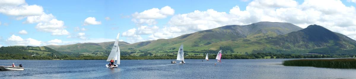 Sailing dinghies out on Bassenthwaite Lake with Skiddaw behind
