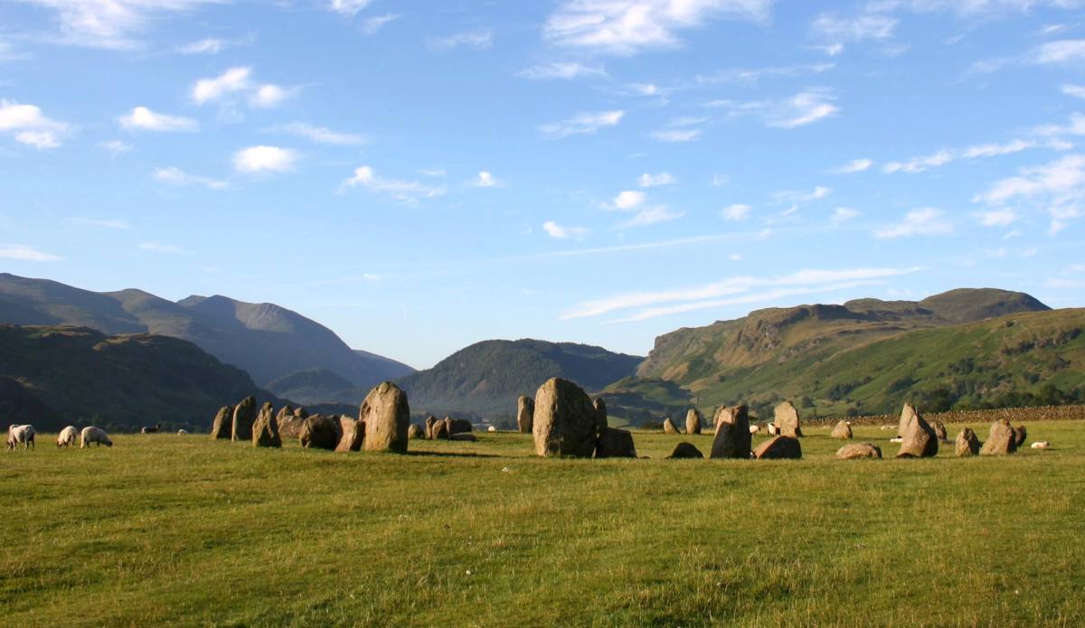 The Castlerigg stone circle on open grass with the fells rising all around