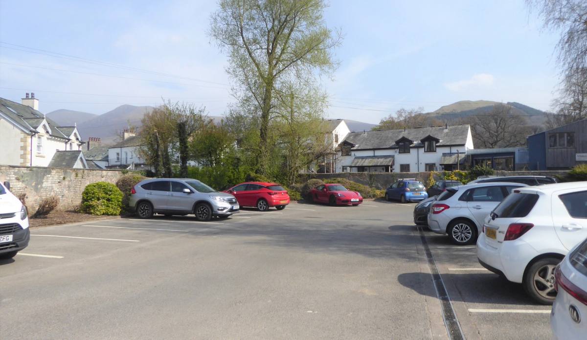 Cars parked at Otley Road car park in Keswick with the fells behind