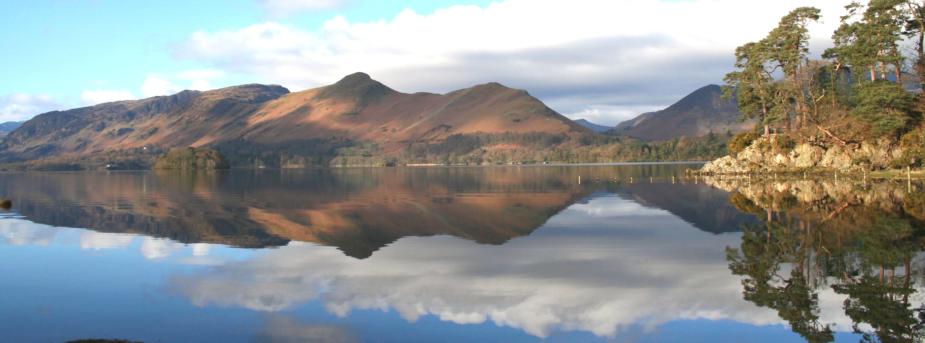 Derwentwater lying still with the fells and cloud reflected the length of it