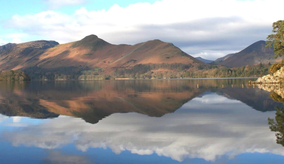 Derwentwater lying still with the fells and cloud reflected the length of it