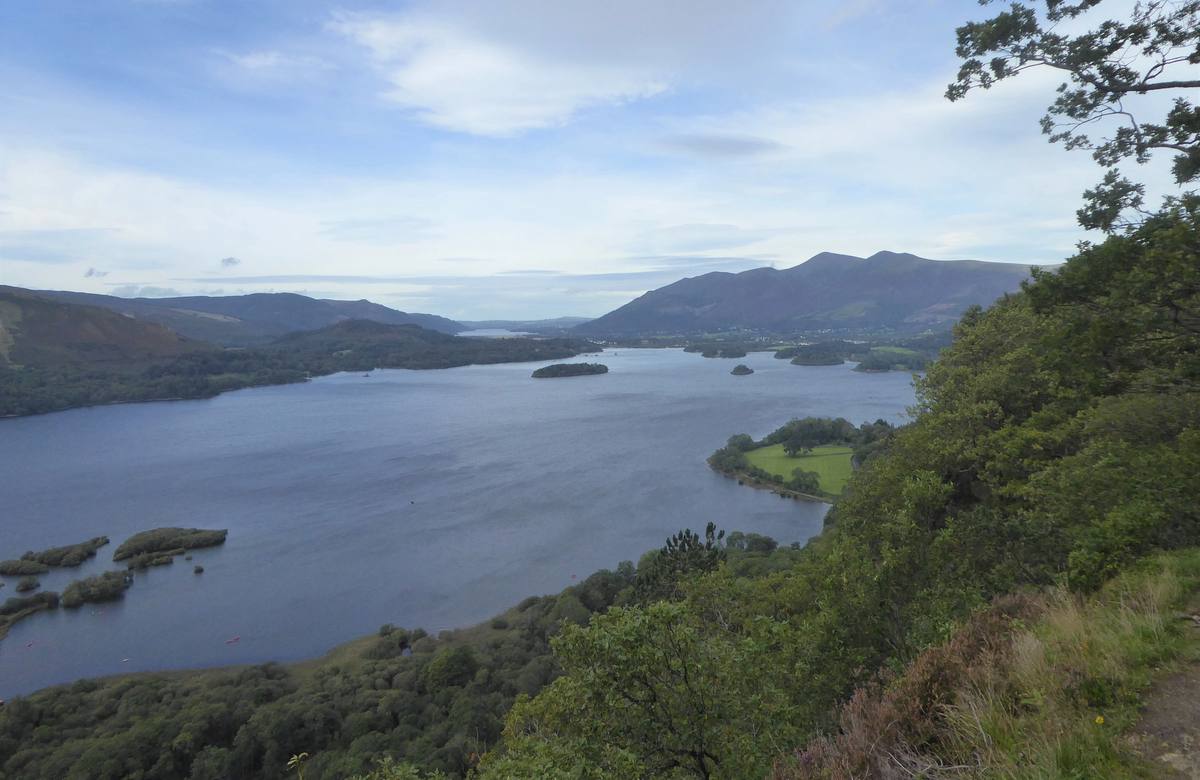 Derwentwater and the vale seen from the viewpoint above Ashness with a walker looking on