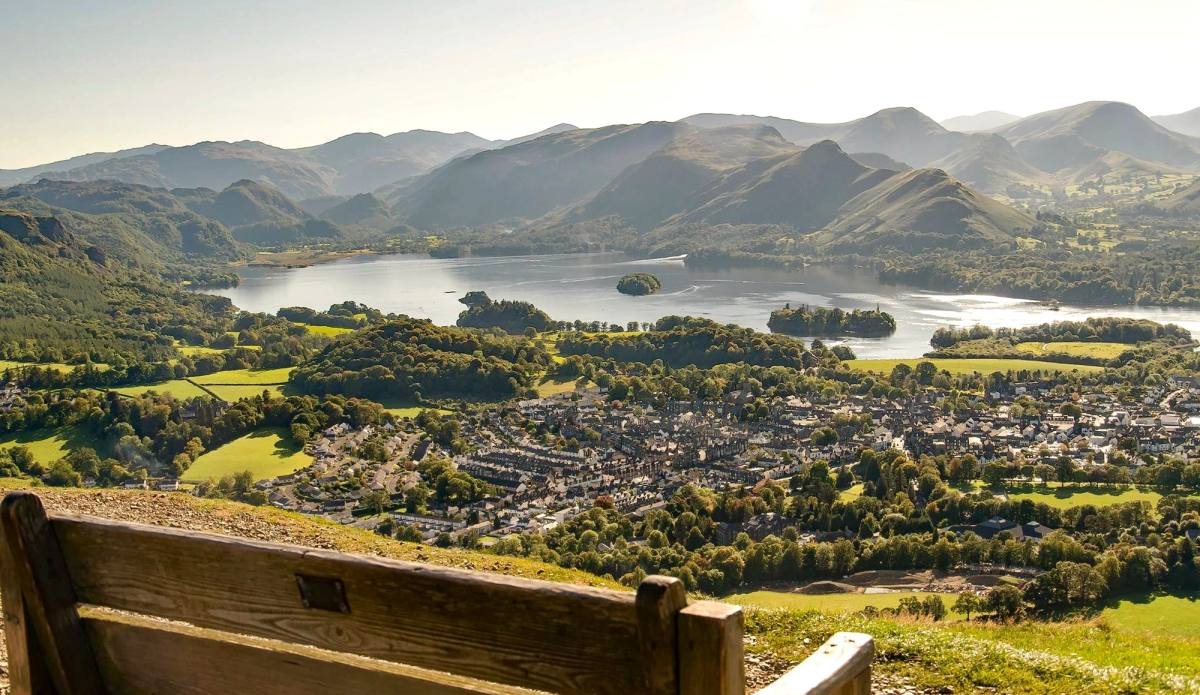 A wooden gate at the summit path with Keswick and the lake laid out below