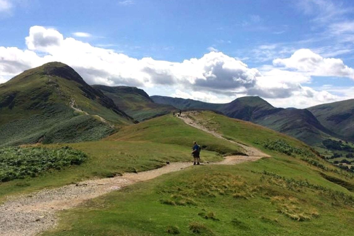 Walkers strung out along the grassy ridge path over Catbells