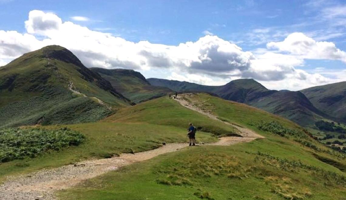 Walkers strung out along the grassy ridge path over Catbells