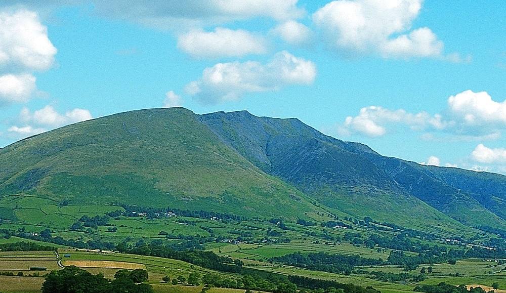The green flanks and gullies of Blencathra seen across the vale from the south