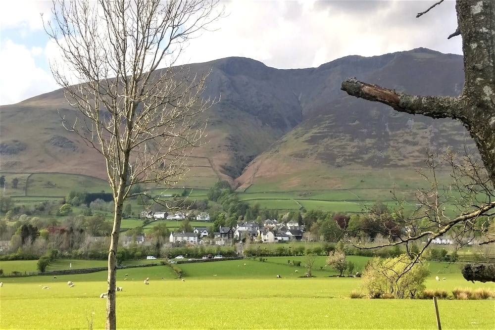 Threlkeld village and its fields framed by bare winter branches with Blencathra above