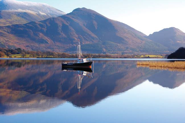 Sailing dinghies out on Bassenthwaite Lake with Skiddaw behind