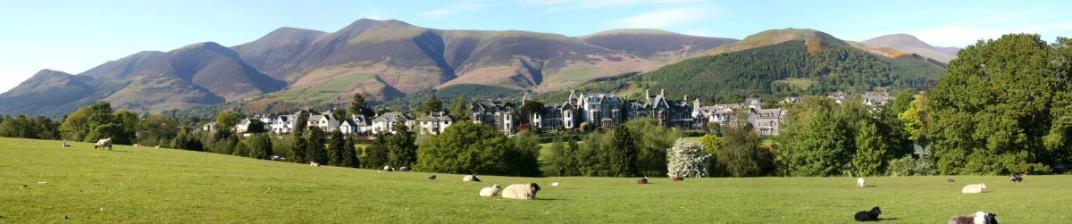 Sheep grazing in fields with Keswick and the whole line of the fells behind