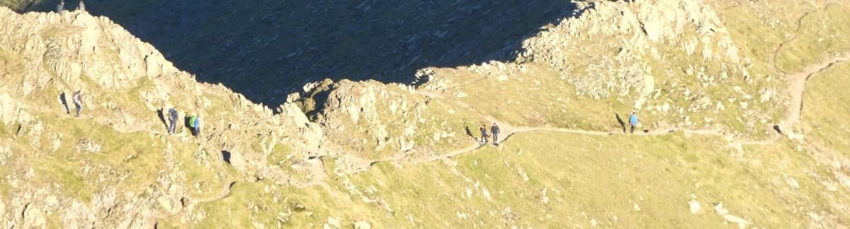 A narrow path picking along the top of a bare rocky ridge
