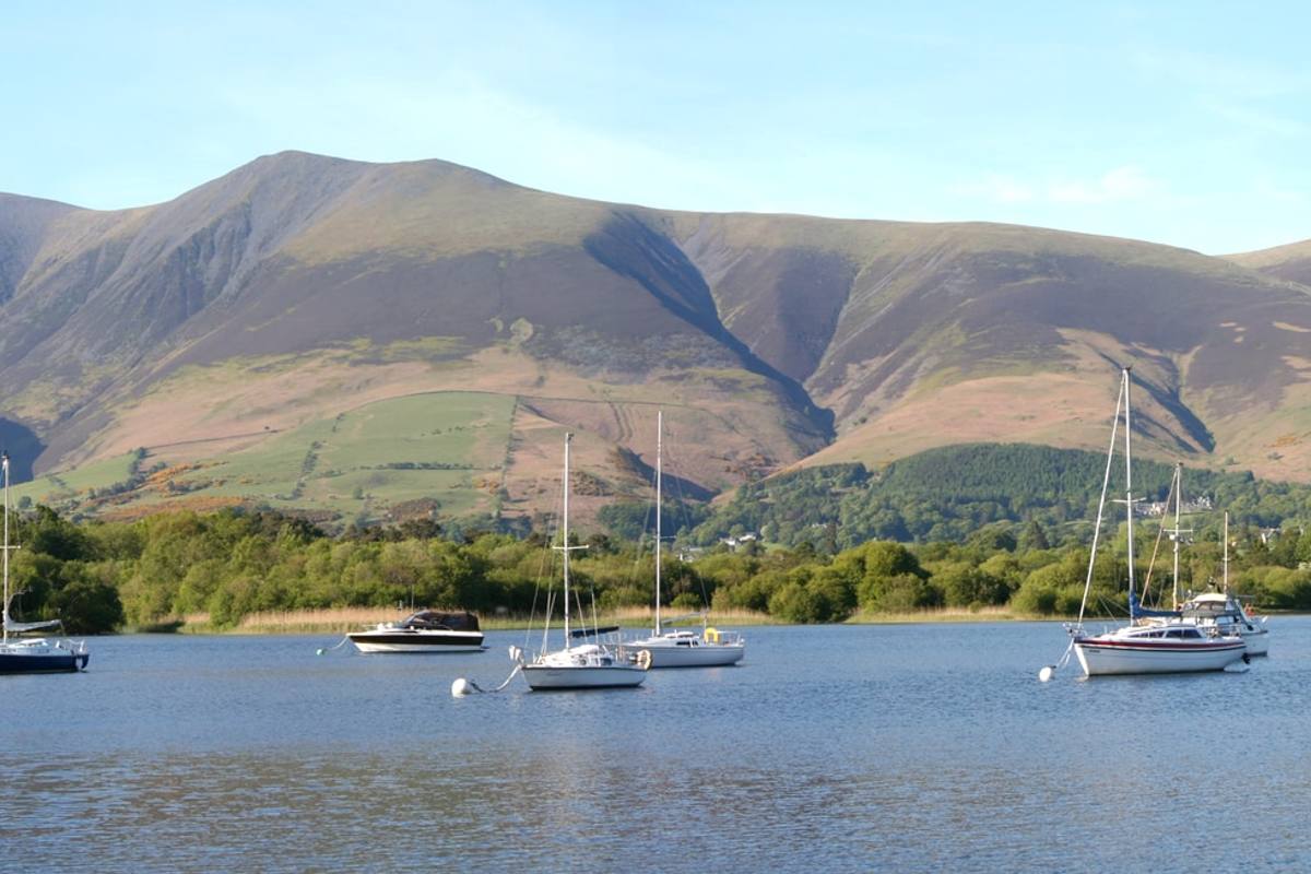 Yachts at their moorings on Bassenthwaite Lake with the long fell ridge behind
