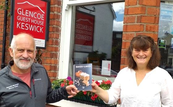 Author of bakes in the lakes with representative of Keswick Mountain Rescue