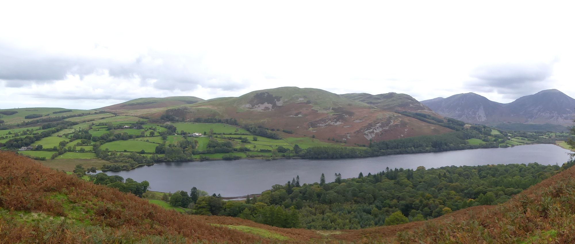 Low mist lying across a lake with fells faint behind it