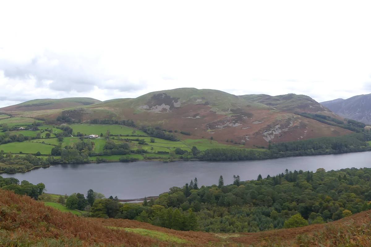 Low mist lying across a lake with fells faint behind it