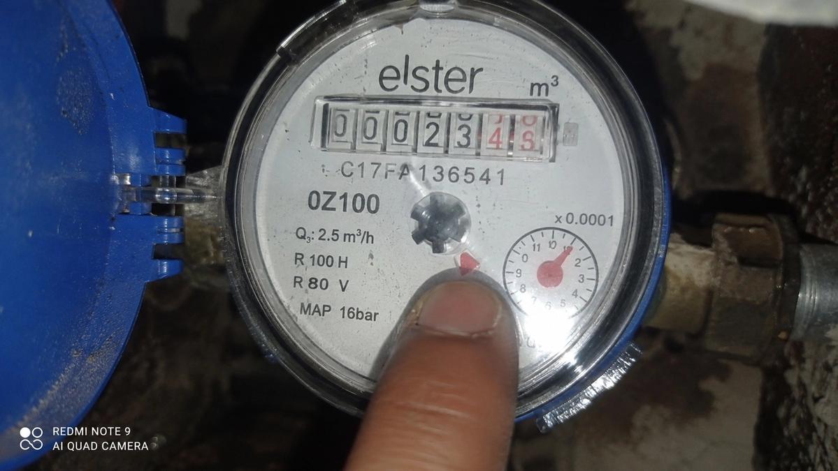 Close-up of a water meter dial with leak indicator turning during a leak check