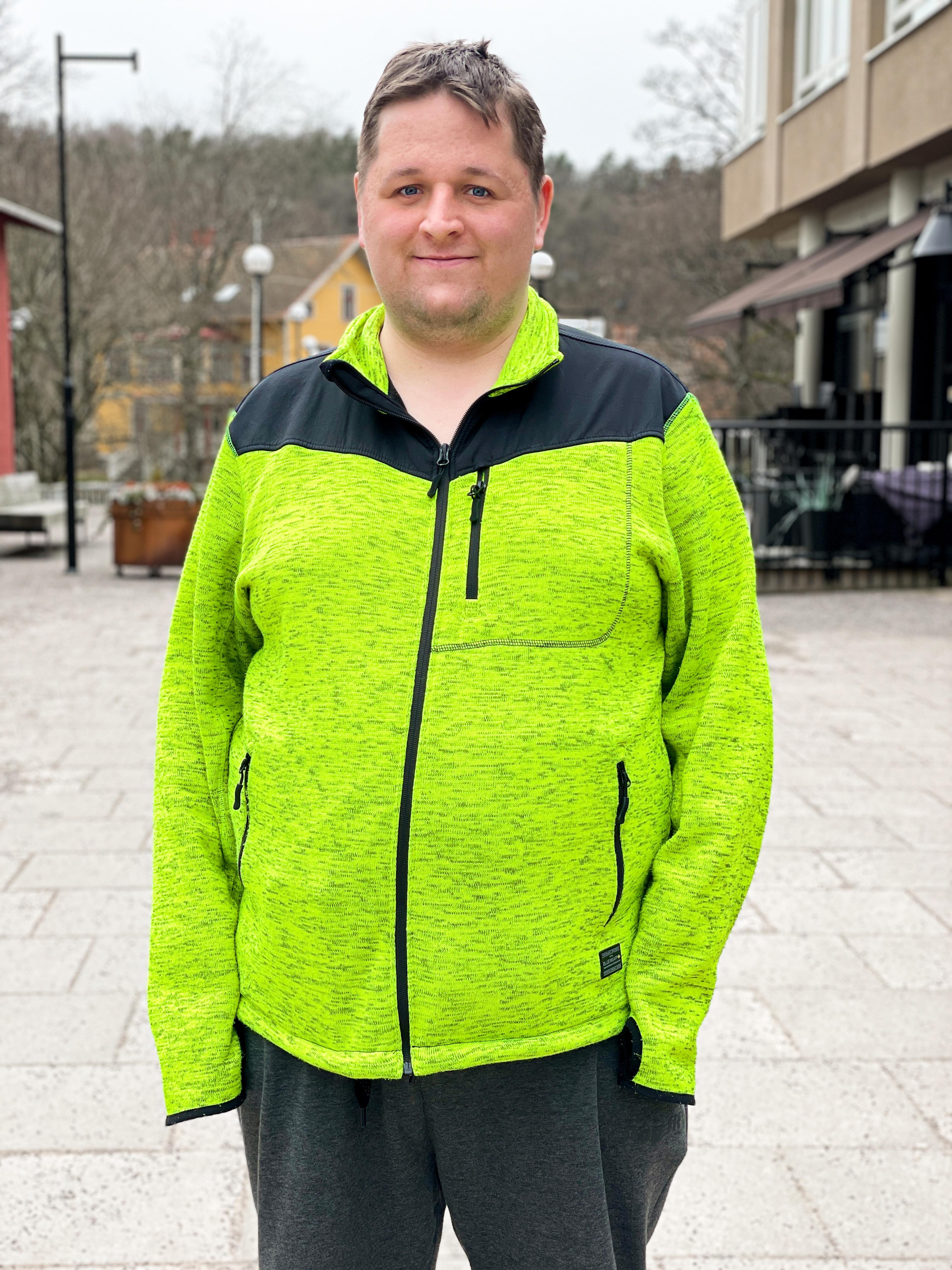 Faktum vendor Hannes smiles for the camera wearing a fluorescent green and black zip up jacket