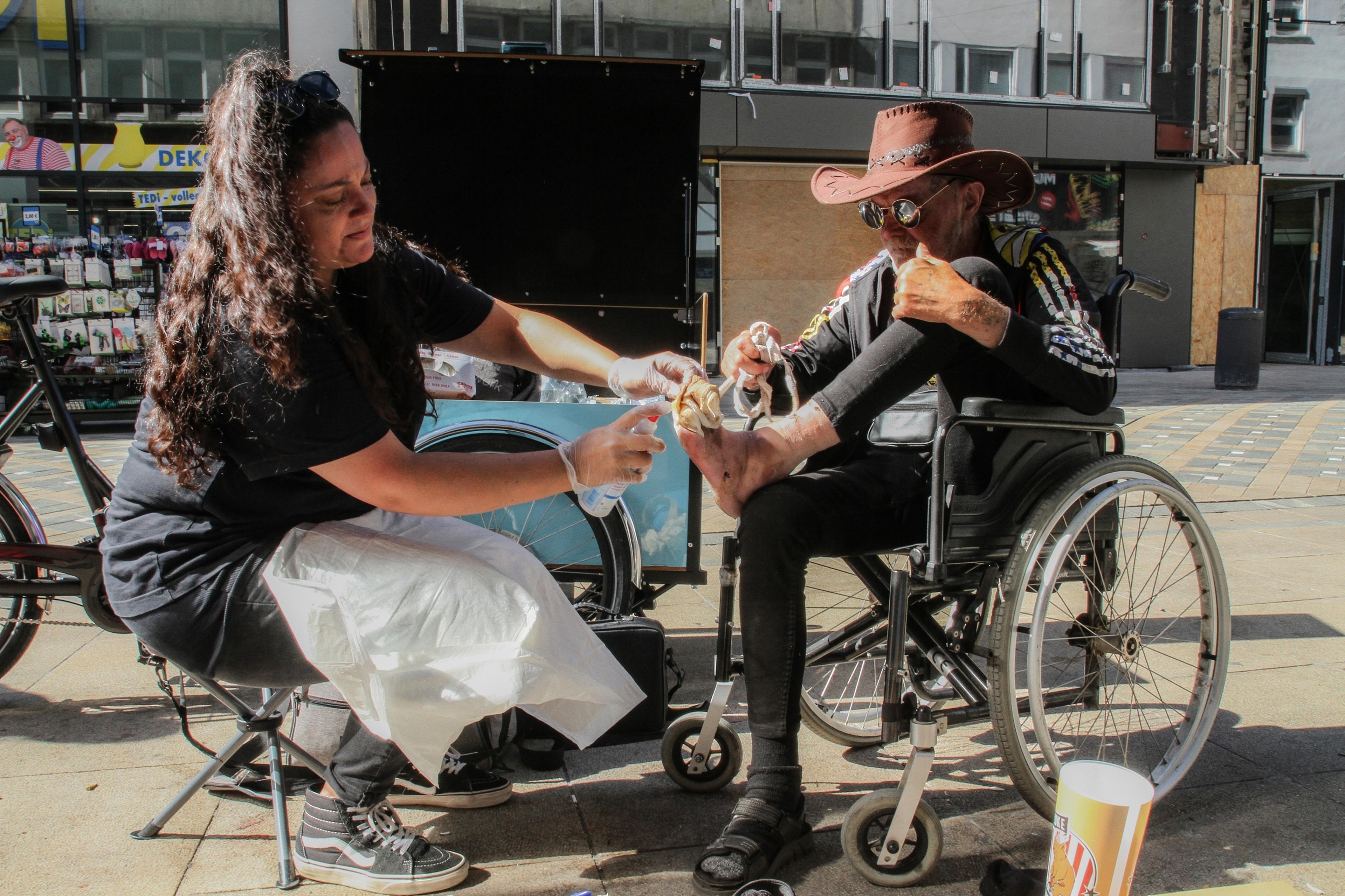 a woman dresses an injury on a mans foot