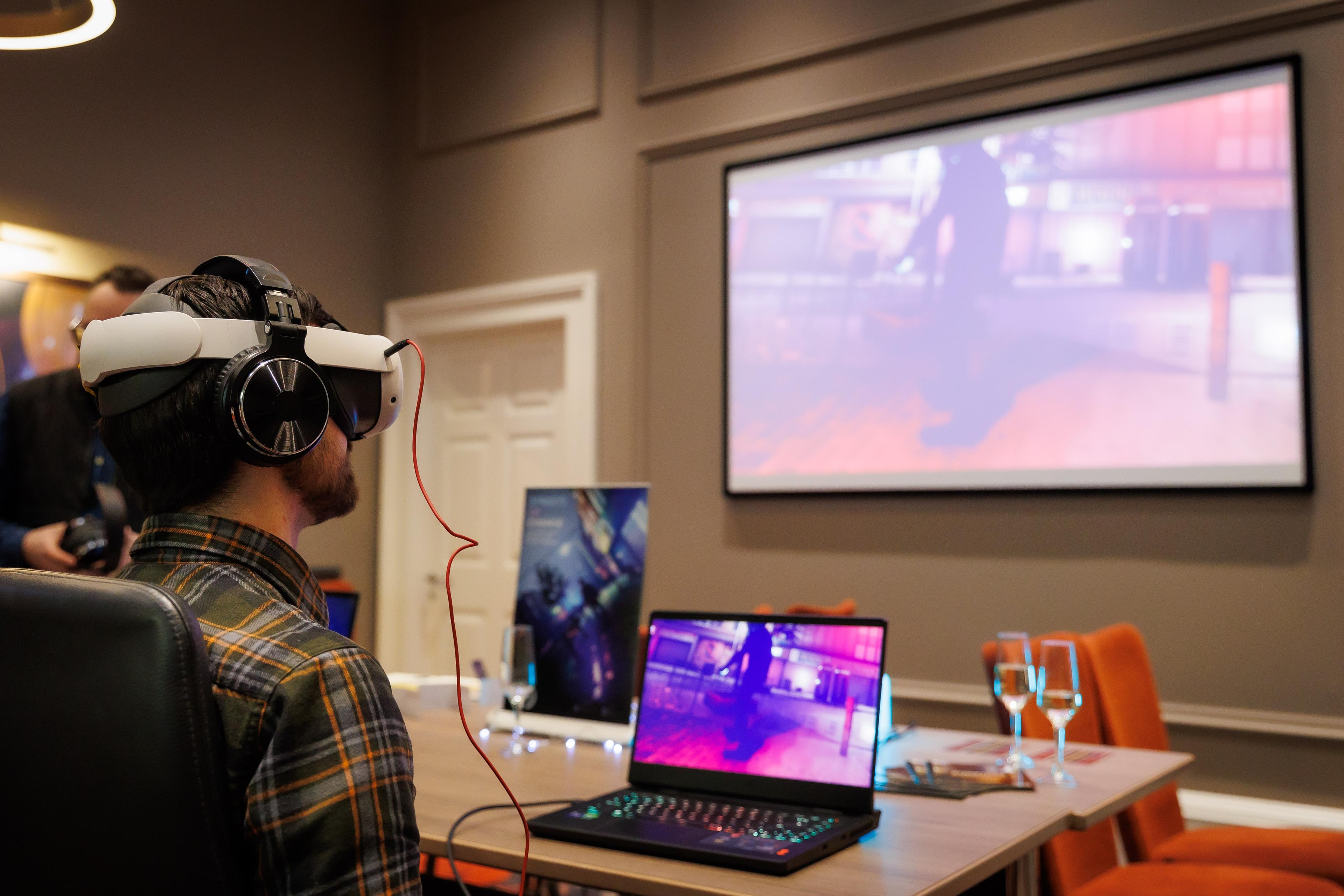 man in a chair using a VR headset with a screen in front of him