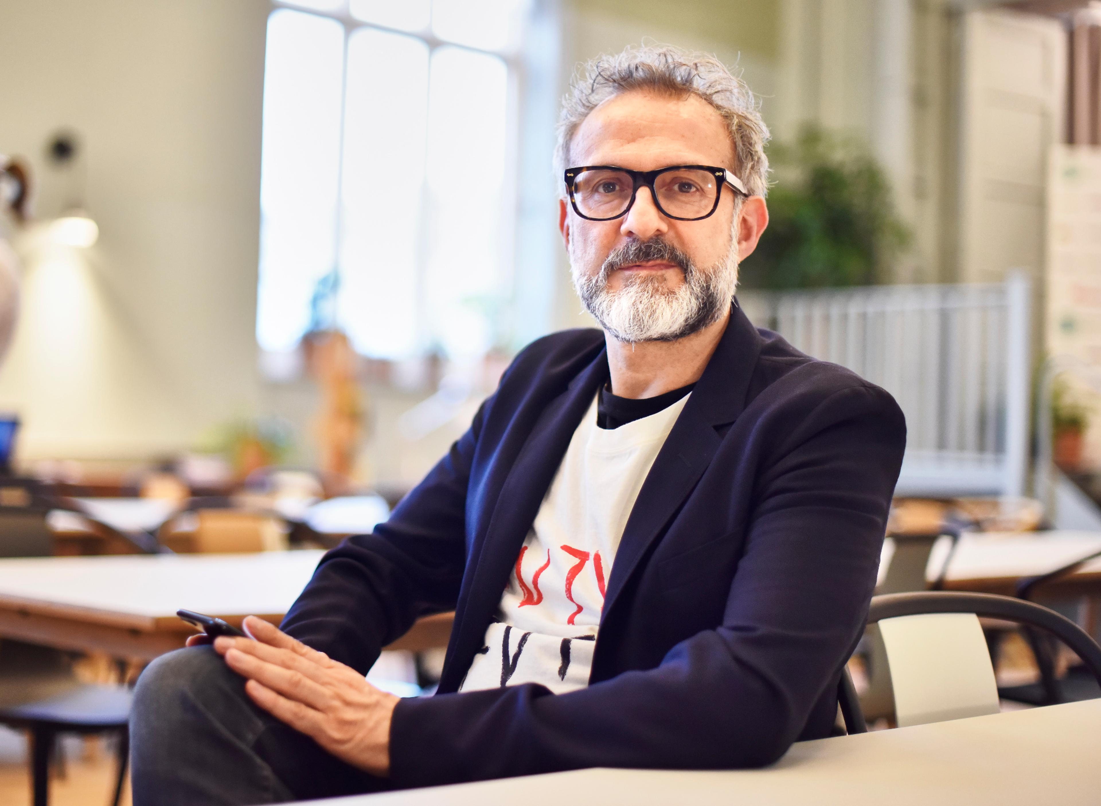 Massimo Bottura wears glasses and looks at the camera