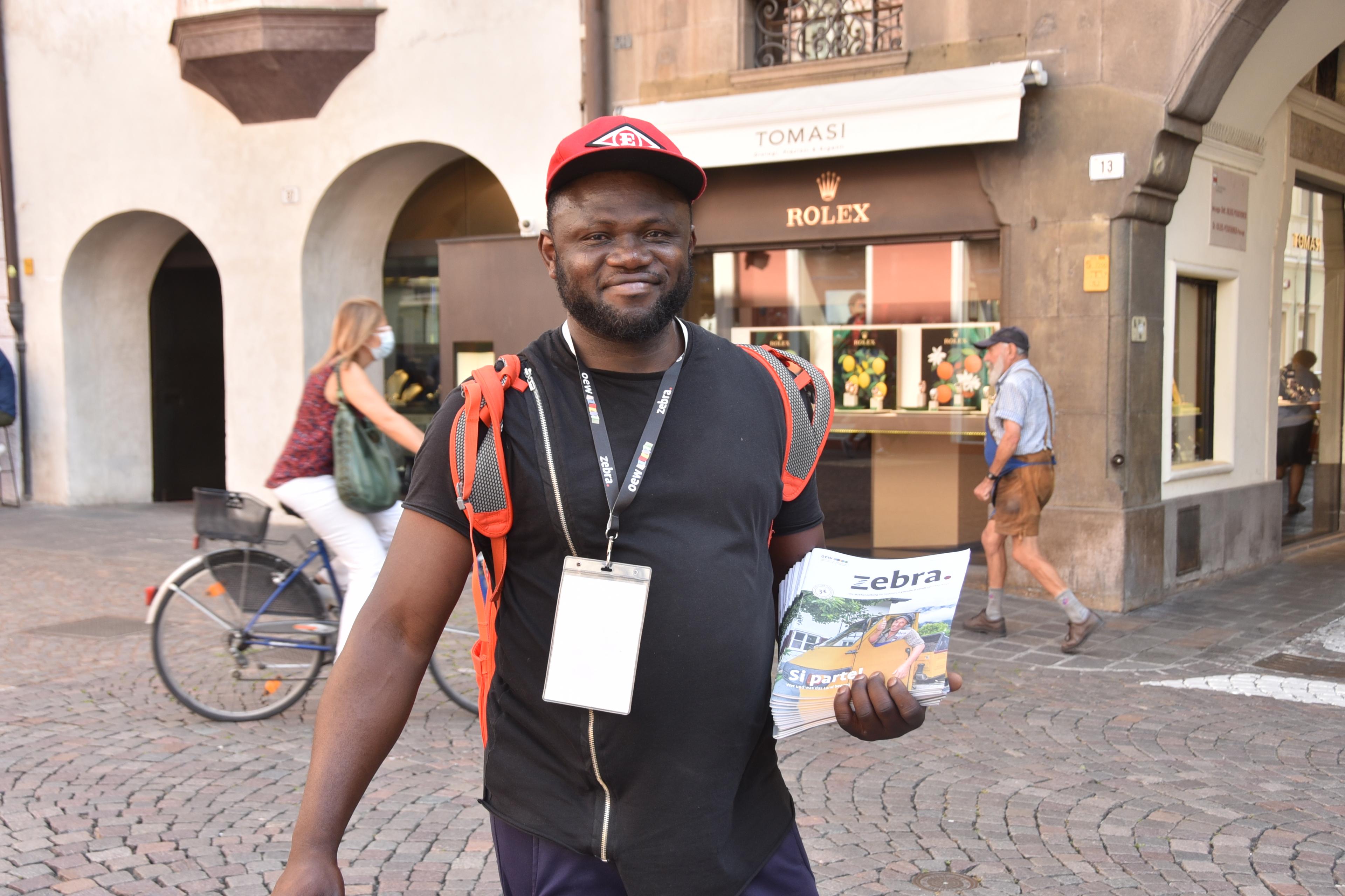 man standing in street with street paper