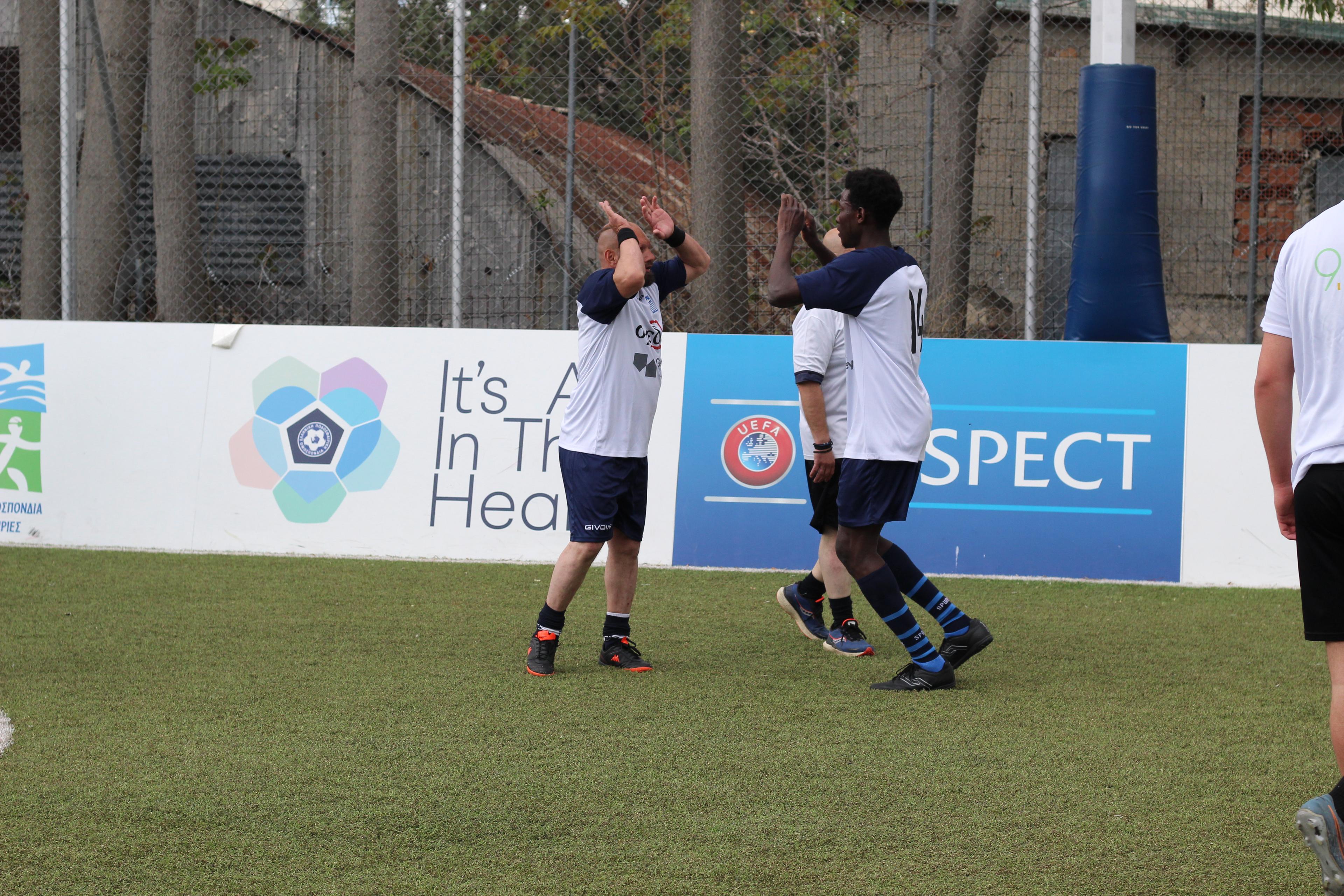 Members of the Greek street soccer team celebrate with each other after scoring a goal