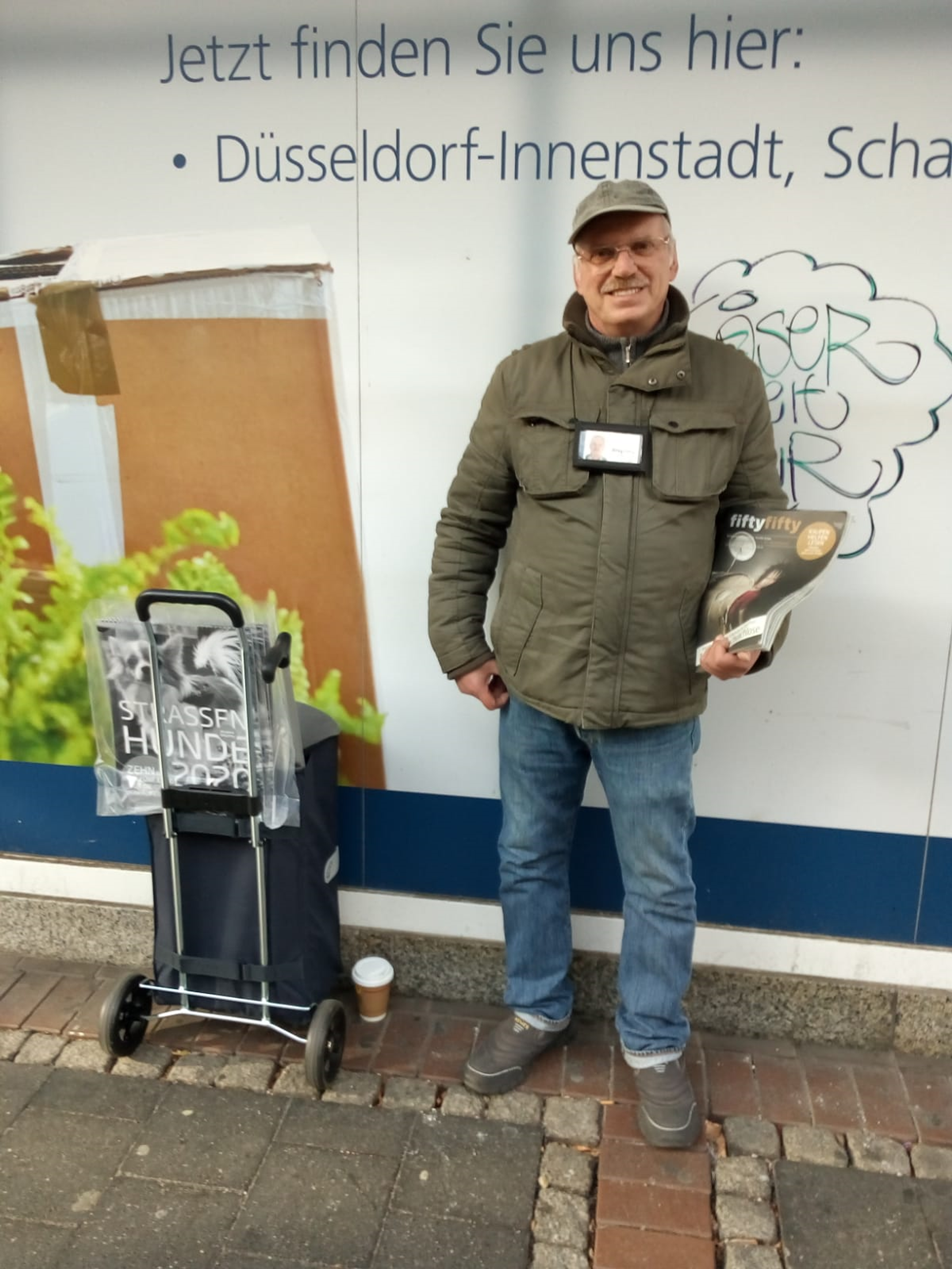 Man stands next to trolley with magazines