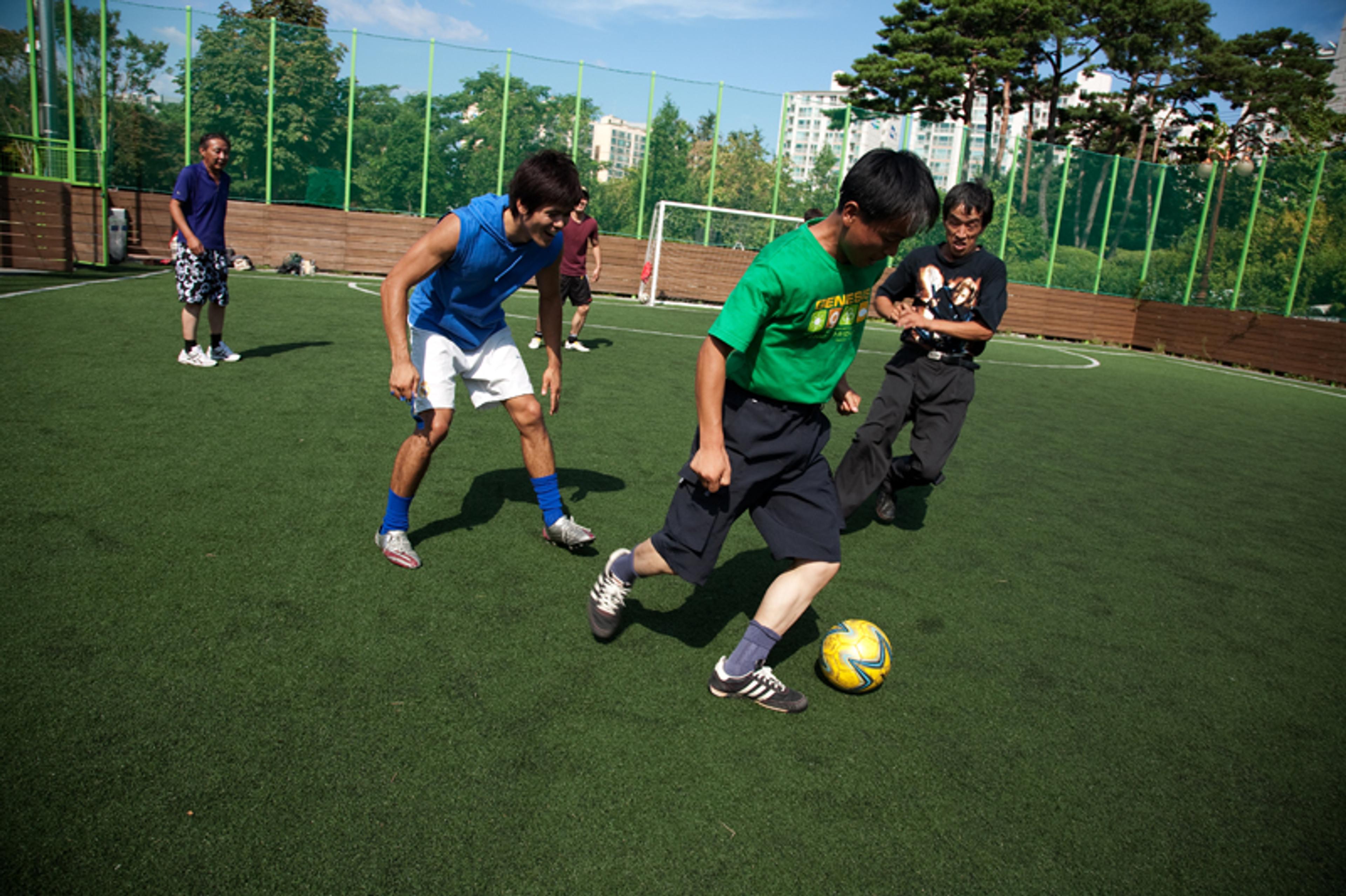 Korean street soccer project participants play football on a 5-a-side pitch