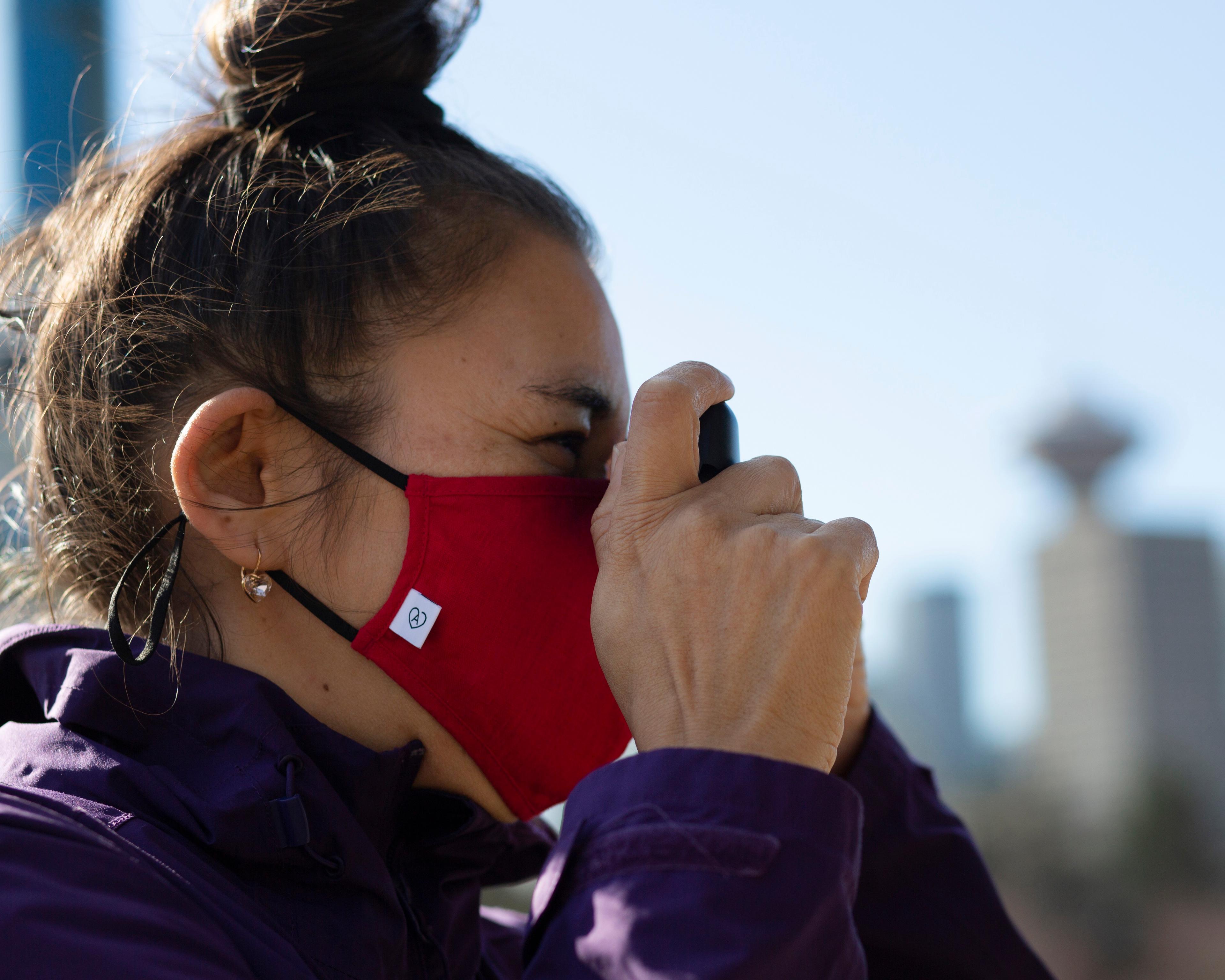 Woman in a mask uses a camera