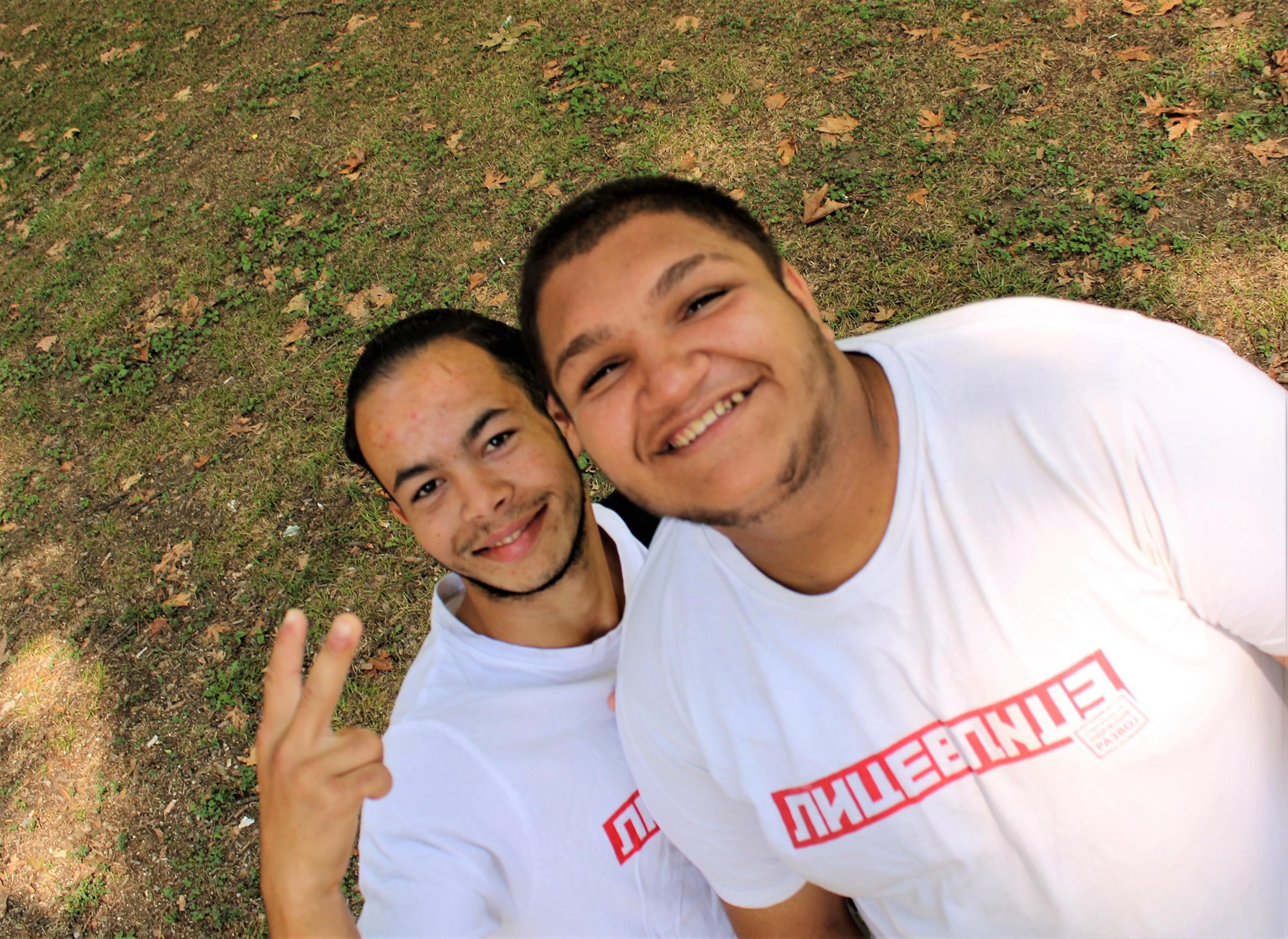 Lice v Lice vendors Valentin and Memet wear white t-shirts with the magazine's logo in red. They are smiling.