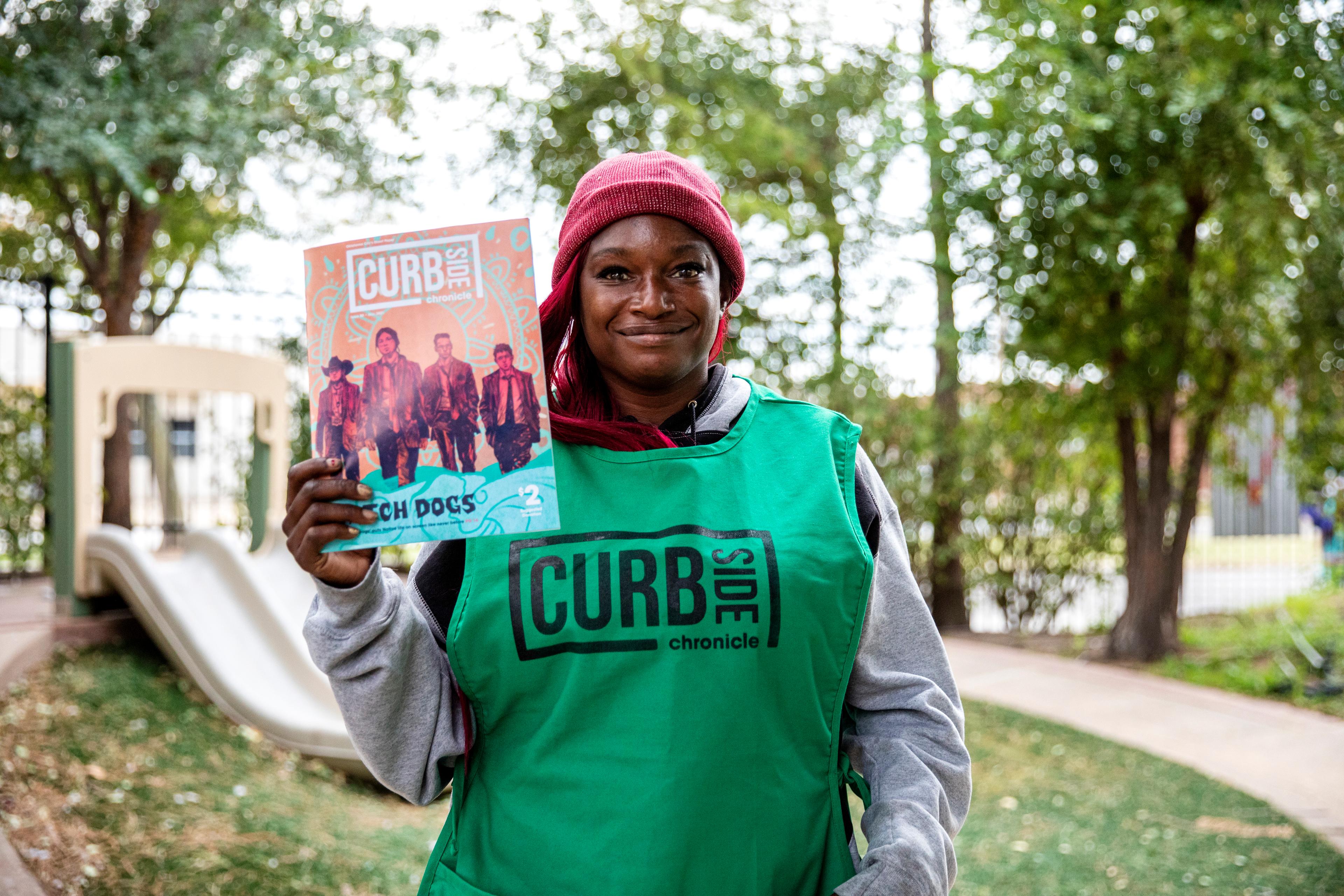 Woman holding Curbside Chronicle Street paper 